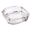 Elegant crystal glass ashtray with four cigar slots on a modern wooden table.