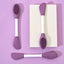 Double-headed silicone mask brush with a pink silicone head and white handle.