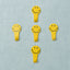 A set of five white self adhesive hooks displayed on a clean surface.