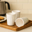 Set of three reusable plastic coffee and tea cups for daily use.