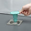 Silicone floor drain stopper preventing hair and odors in a modern bathroom.