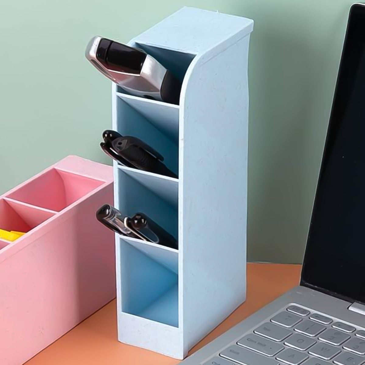 Clear plastic desktop pen holder with four compartments, neatly organising pens and pencils. Main image