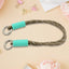A phone with a vibrant multi-colored phone wrist strap attached, held securely.