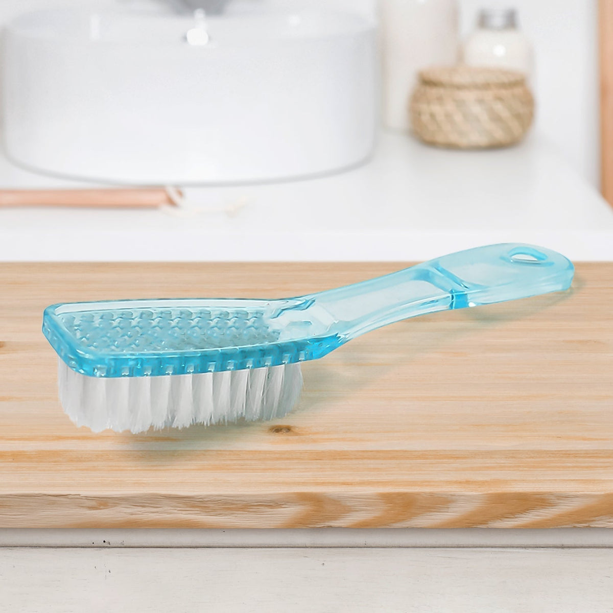 Scrubbing brush with plastic handle cleaning a pair of white shoes. Main image