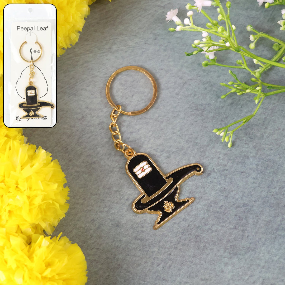 Golden Shivling keychain in metal with intricate design on plain background Main image