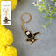 Golden Shivling keychain in metal with intricate design on plain background