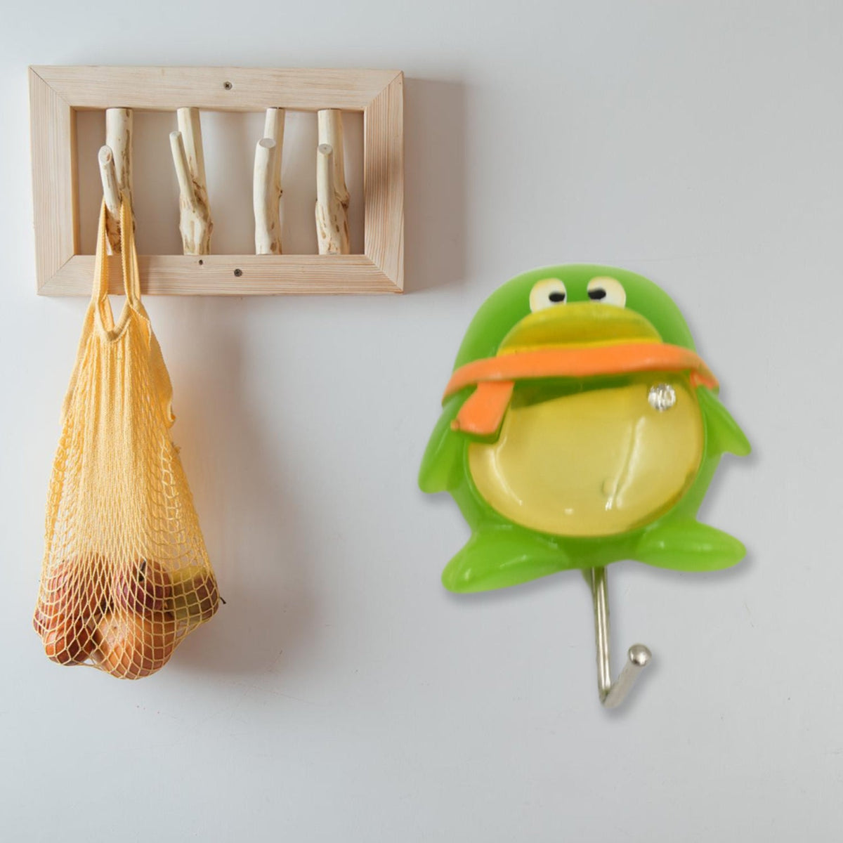 Cute green frog self-adhesive wall hook with strong backing, ready for installation. Main image