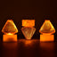 A close-up view of multiple Flameless LED Tea Light Candles glowing warmly on a dark surface.
