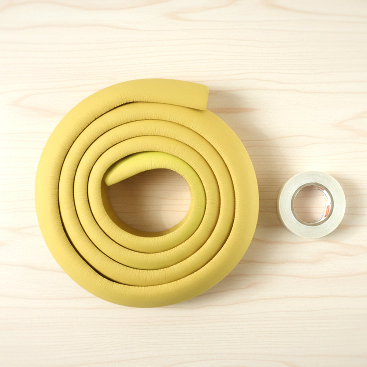 Soft rubber baby corner protector installed on a wooden table edge. Main image