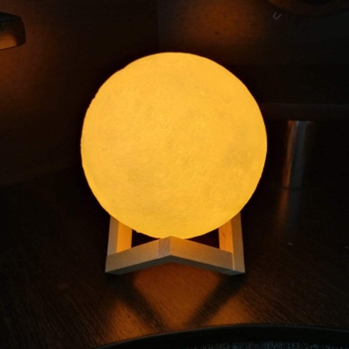 A beautifully lit 3D moon lamp with touch controls on an elegant crystal ball stand. Main image