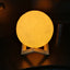 A beautifully lit 3D moon lamp with touch controls on an elegant crystal ball stand.