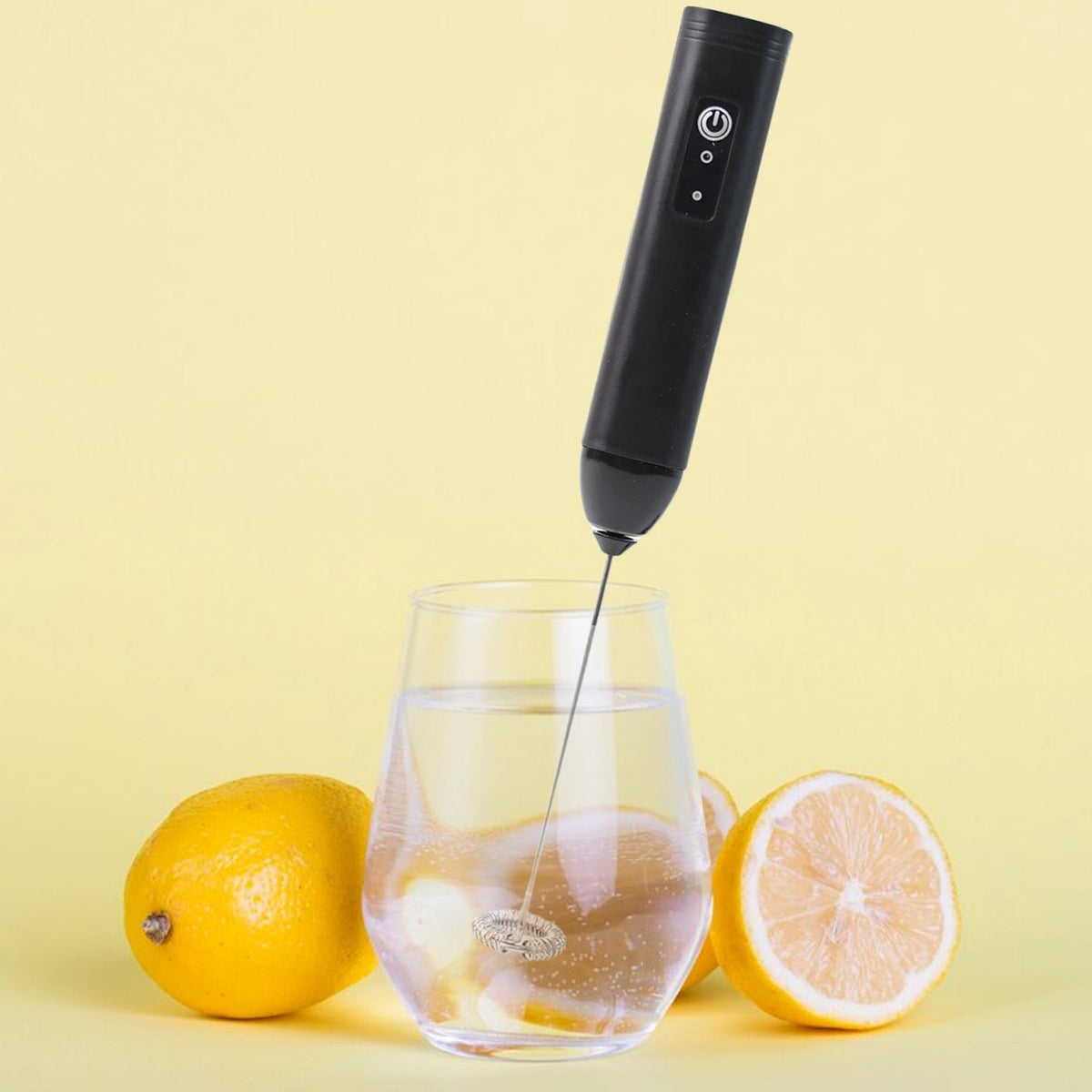 Electric handheld milk frother with stainless steel whisk in use Main image