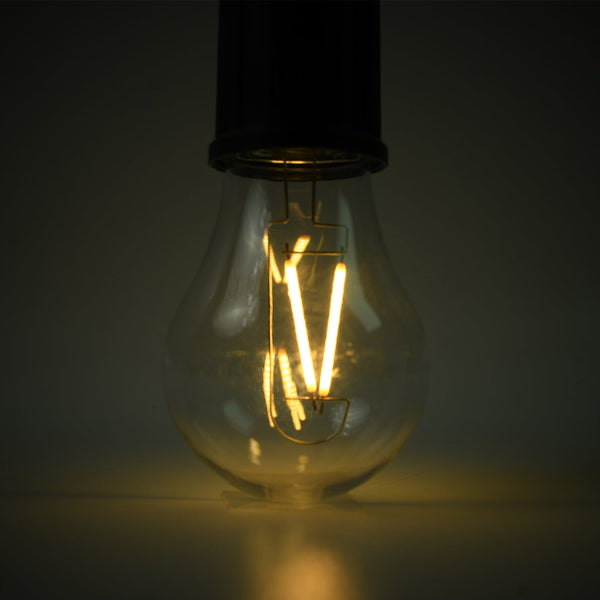A close-up of the clear bulb of a portable LED tent light shows the glowing orange filament against a dark background.