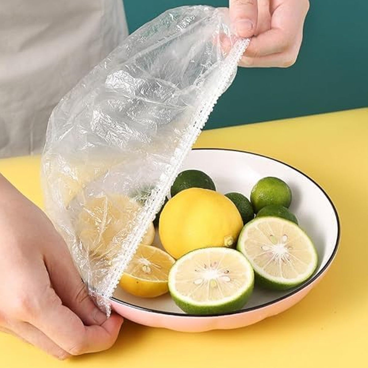 Small elastic food covers stretched over various bowls of fresh food on a kitchen counter. Main image