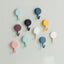 Pack of 10 transparent self-adhesive wall hooks on a white surface.