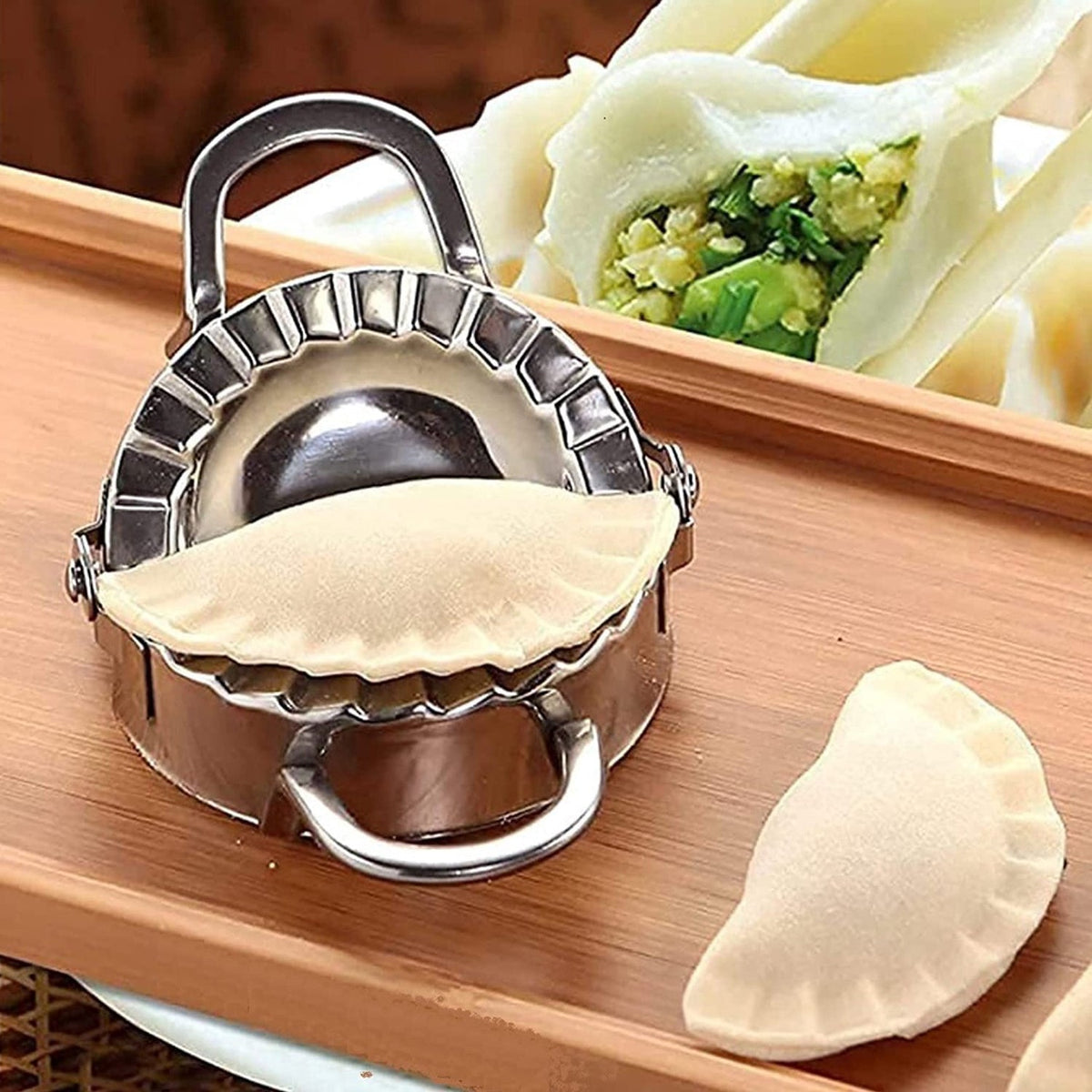 Stainless steel dumpling maker with a perfectly sealed dumpling. Main image