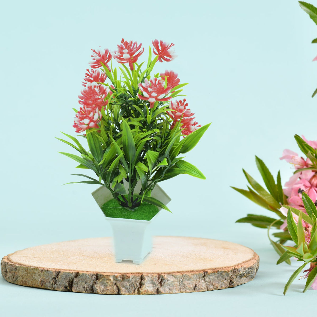 A realistic artificial flower plant with green leaves and pink blossoms in a white pot, perfect for home decor. Main image