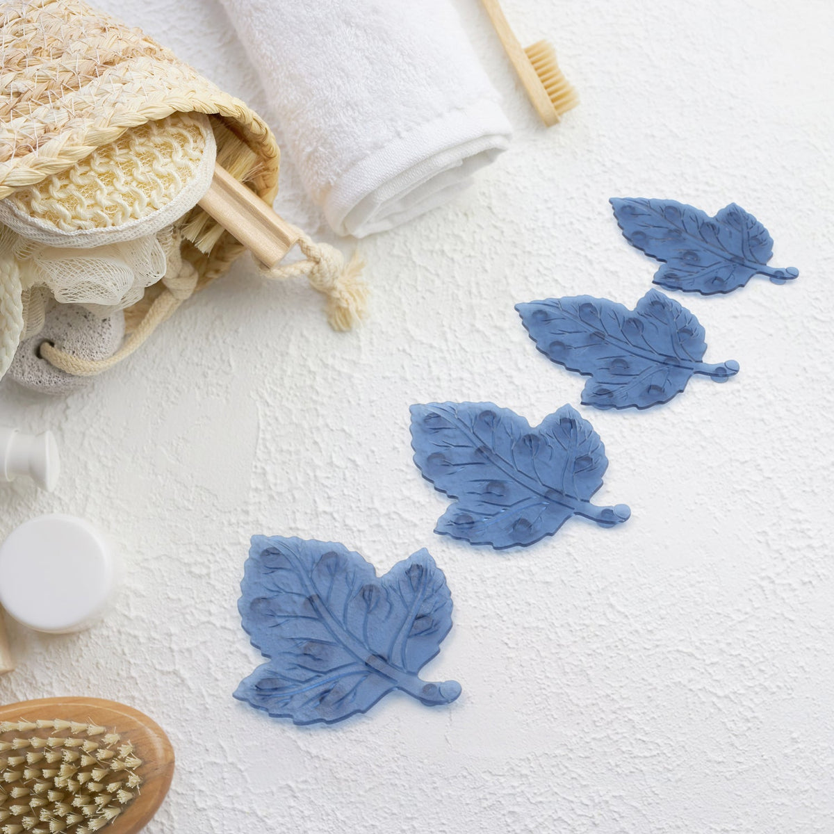 Four colorful leaf-shaped baby anti-slip bath mats with suction cups displayed. Main image