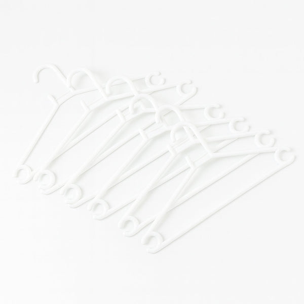 Stack of 6 white plastic clothes hangers ready for use