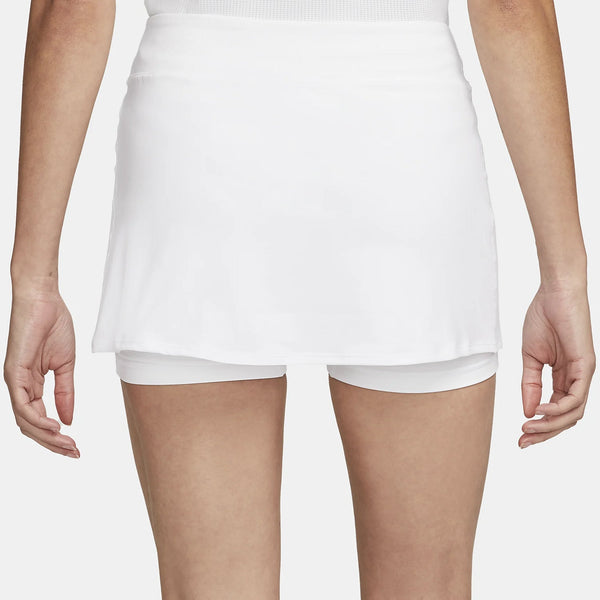Model running in a white high-waisted athletic skort outdoors.