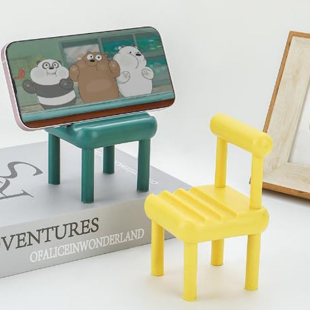 Gambit Mini Chair Phone Stand in natural wood, holding a smartphone upright on a desk. Main image