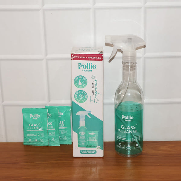 Spray bottle misting concentrated glass cleaner solution on glass surface for cleaning.