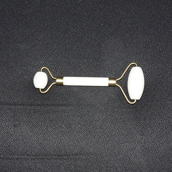 Dual-ended face massage roller displayed on a minimalist white background.