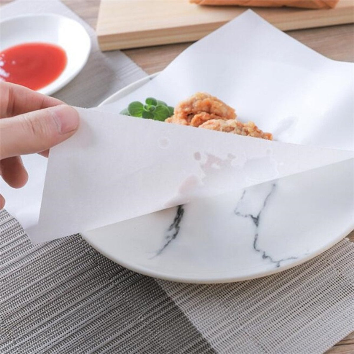 Oil-absorbing cooking paper sheets on a plate with fried food, reducing grease. Main image