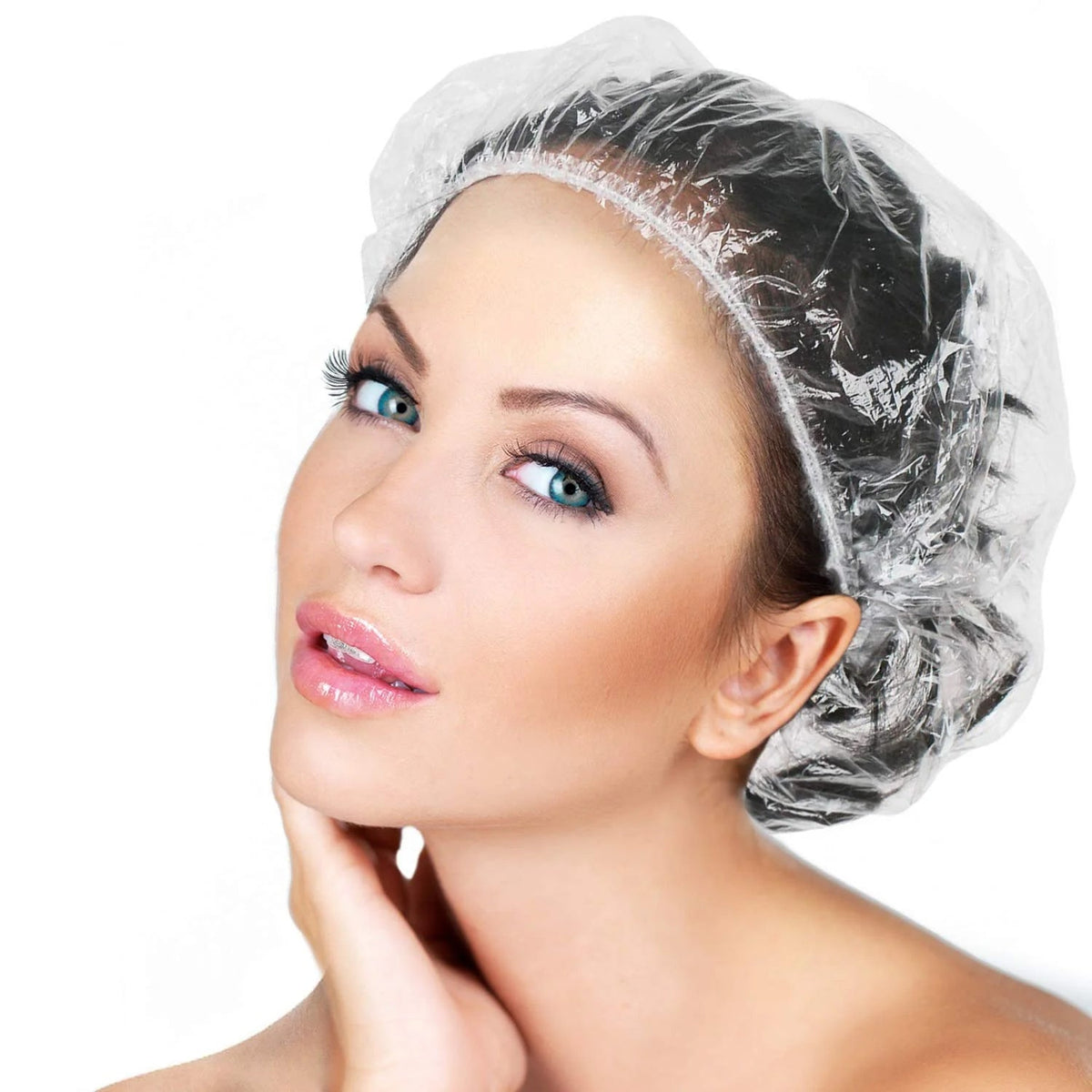 A stack of individually wrapped disposable shower caps, ready for use. Main image