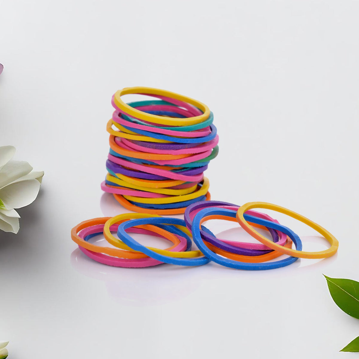 Multicolor rubber bands neatly arranged in a stack on a white surface. Main image