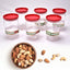 Set of 6 clear air tight kitchen storage containers with green lids.