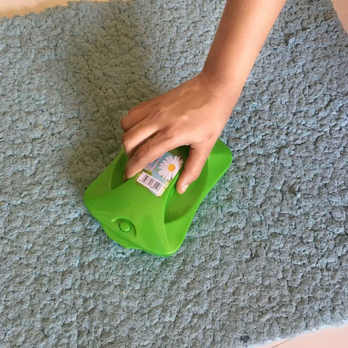 Handheld carpet roller brush efficiently cleaning dust and crumbs from a patterned rug. Main image