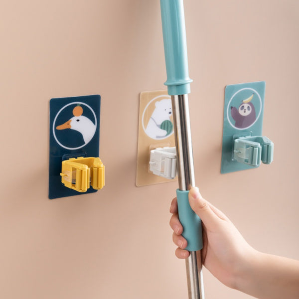 A white self-adhesive mop holder securely gripping a broom handle on a tiled wall. Main image