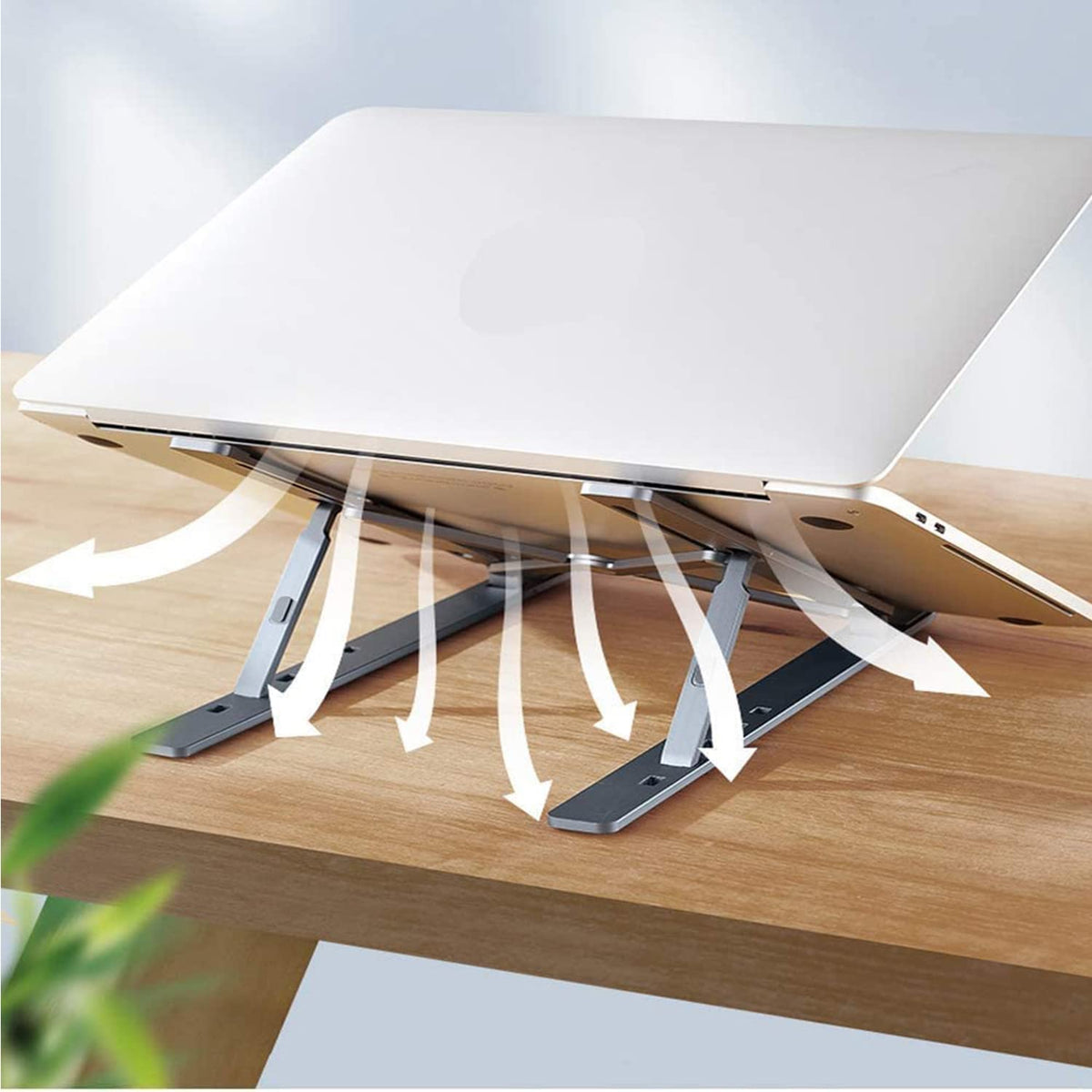 A silver metal portable laptop stand elevating a laptop for ergonomic comfort on a desk. Main image