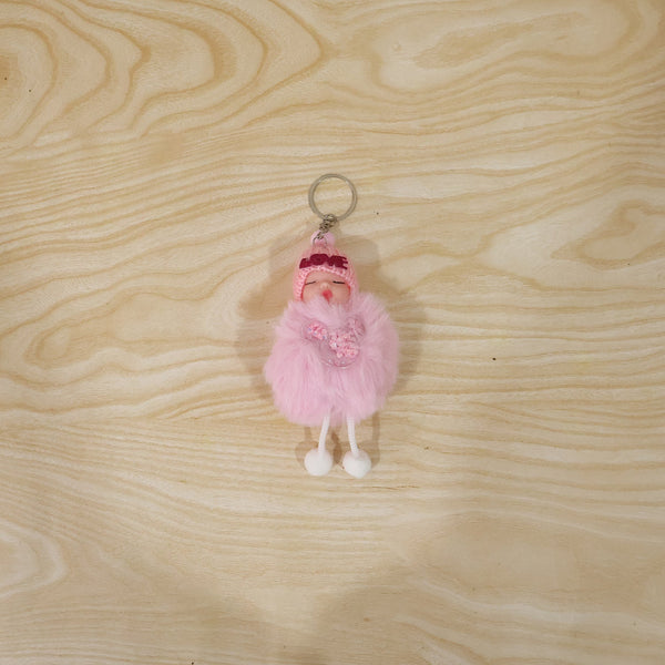 Plush doll keychain hanging on bag strap showing soft fur ball charm