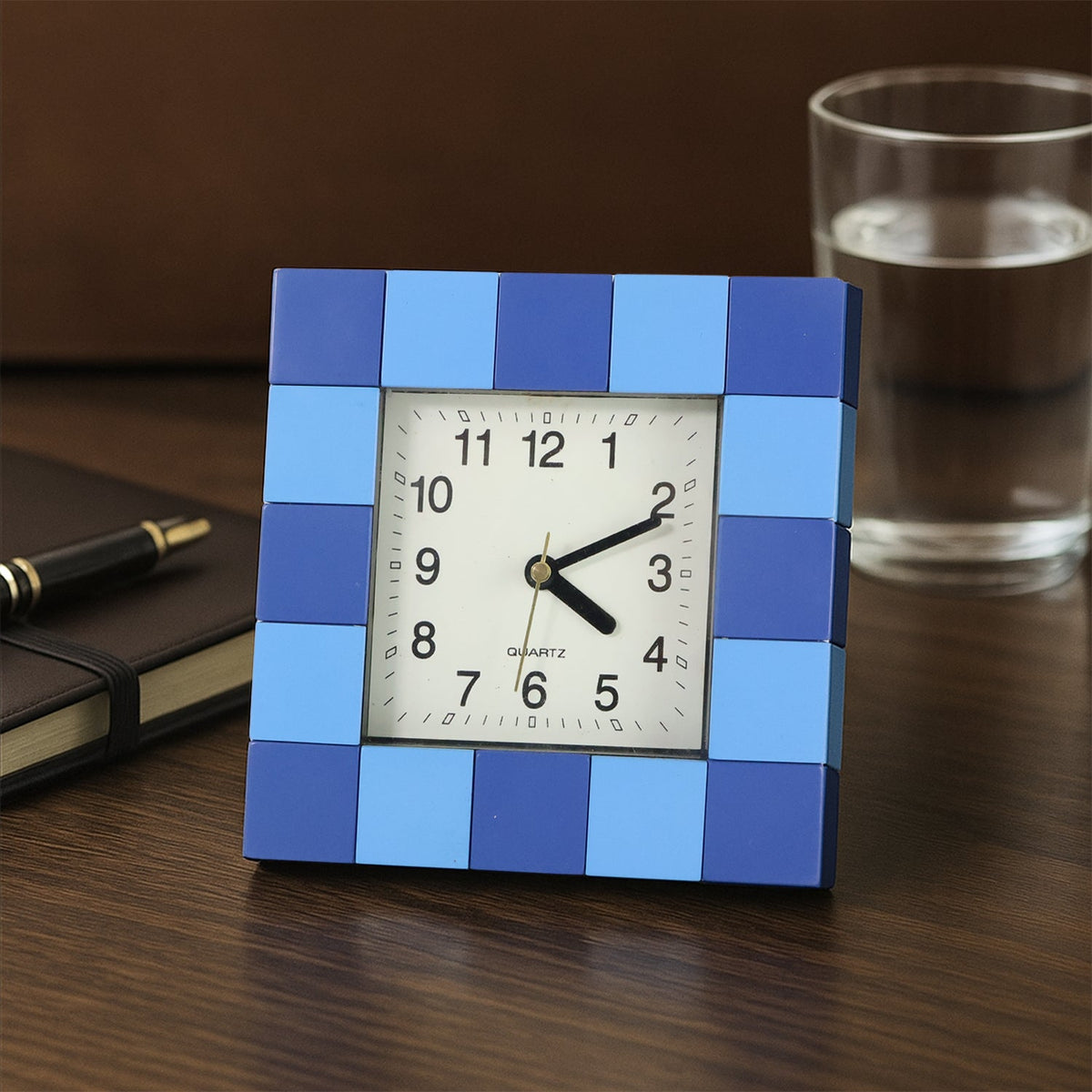 Modern square table clock with a bold frame, displayed on a desk. Main image