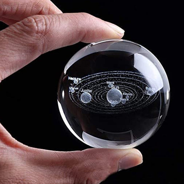 Decorative astronomy crystal ball lamp displayed on a modern desk.