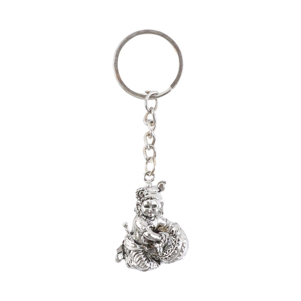 Bal Krishna Makhan Chor keychain displayed against a wooden backdrop