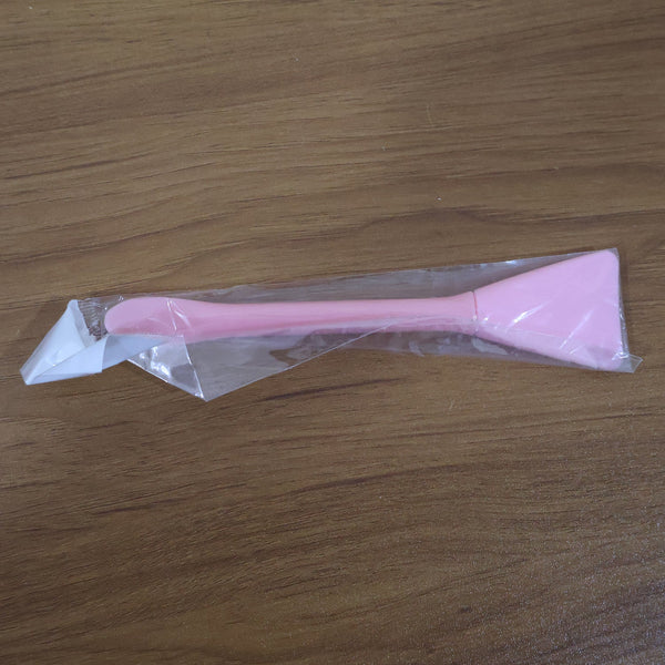 Close-up image of silicone facial mask applicator tool