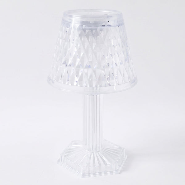 Modern LED crystal lamp displayed on a wooden shelf in a home setting.
