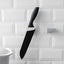 A sleek black punch-free wall hanging knife holder mounted on a kitchen wall, showcasing its modern design and space-saving functionality.