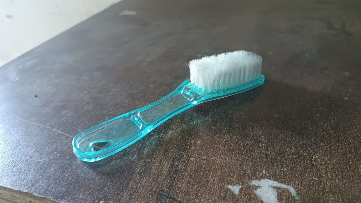 Plastic scrubbing brush featuring an ergonomic handle design.