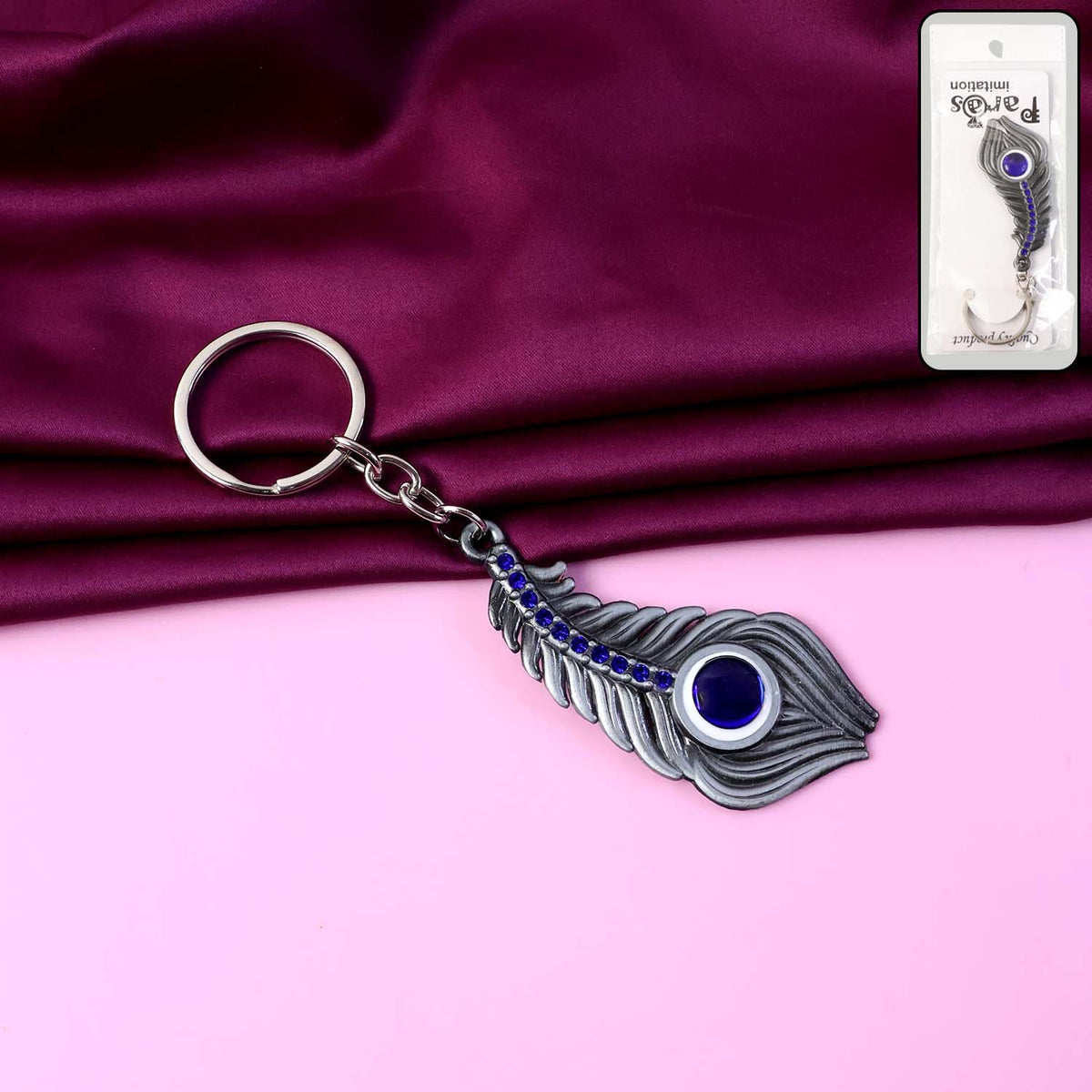 Elegant metal peacock feather keychain featuring blue gem accent Main image